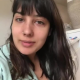 From under the toilet, a very cute girl pushes out a hang that drops, with a solid look at the product. Filmed from a between the legs perspective. Vertical format video. Over a minute.